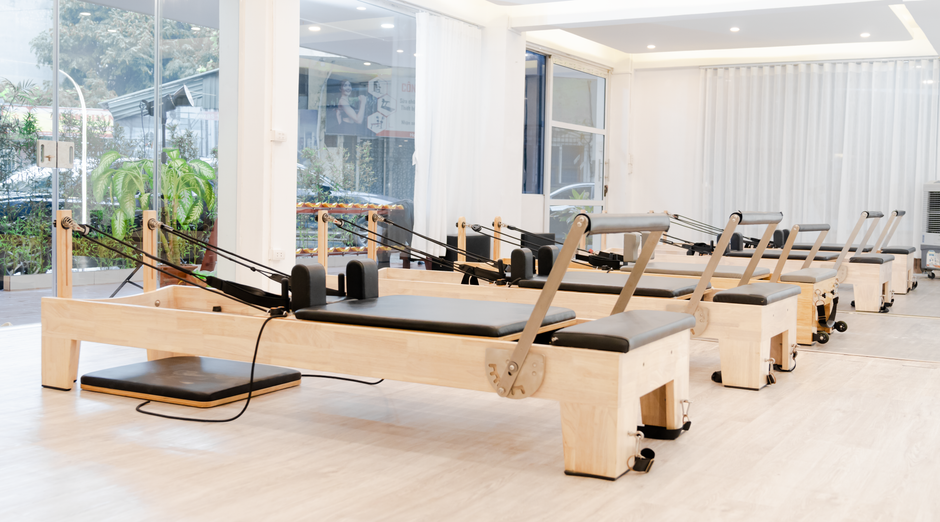 A diverse group of people participating in a yoga class inside a bright, modern, and minimal studio, representing finding a new wellness community.