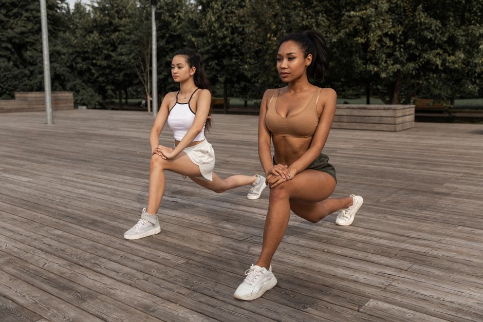 A fit runner in athletic gear performs a lunge outdoors on a bright day, highlighting the importance of strength training for injury prevention and power.