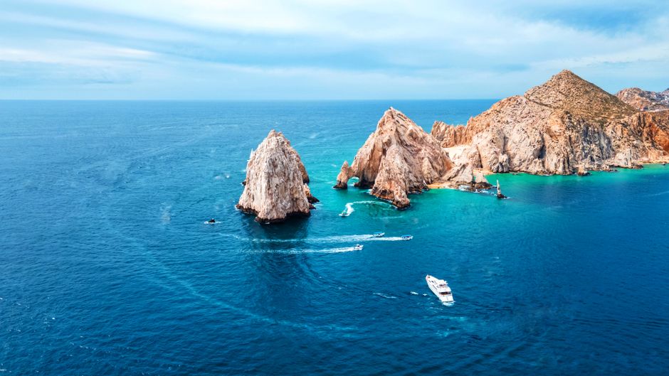 Bright, modern villa in Los Cabos with an infinity pool overlooking a calm blue ocean, representing a peaceful sanctuary f...