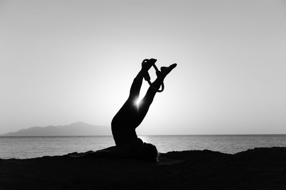 A person practicing yoga on a serene beach in Los Cabos during a beautiful sunrise, embodying a healthy and mindful lifestyle.